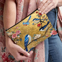 Load image into Gallery viewer, Clutch bag with floral and bird design held by a person wearing a floral dress.