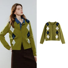 Load image into Gallery viewer, A women's cropped button-front cardigan sweater shown on a model against a light gray studio background, with a smaller flat product view on the right. The cardigan is olive green with argyle diamond panels in white, navy, and olive green, layered over a blue collared shirt and worn with a dark brown skirt.