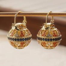 Load image into Gallery viewer, Gold earrings with gemstones on a reflective surface
