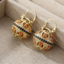 Load image into Gallery viewer, Gold earrings with gemstones on a beige fabric background
