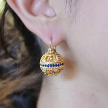 Load image into Gallery viewer, Gold earring with colorful stones worn by a person

Details
